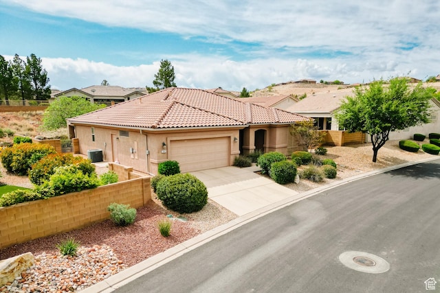 view of front facade featuring central AC, concrete driveway, a tiled roof, fence, and a garage