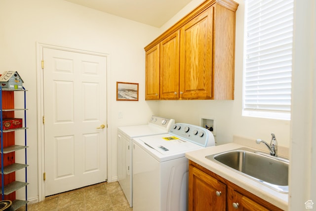 clothes washing area featuring separate washer and dryer, a sink, and cabinet space