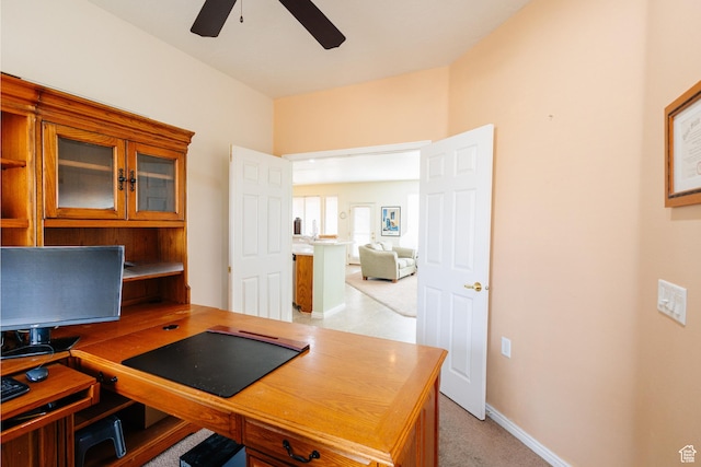 office featuring light carpet, baseboards, and ceiling fan