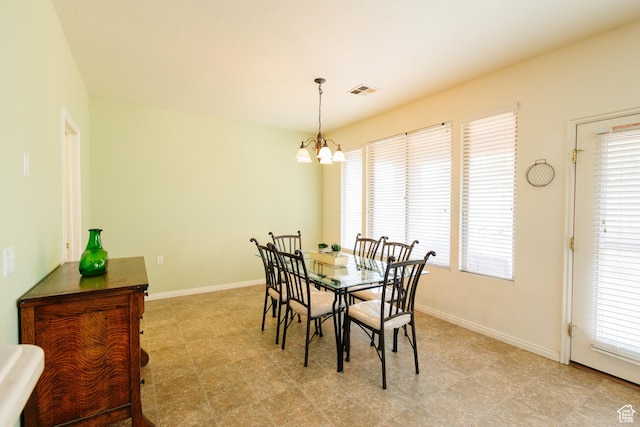 dining area featuring a chandelier, visible vents, and baseboards