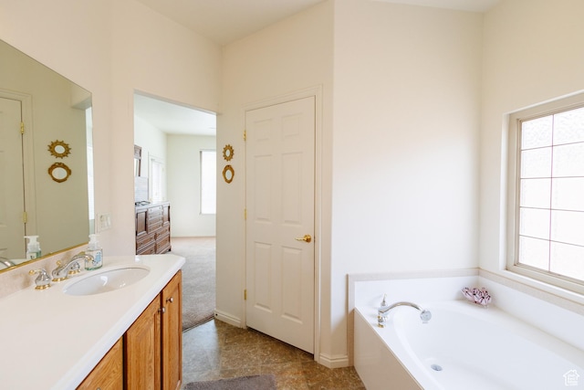 full bath featuring a bath, a healthy amount of sunlight, and vanity