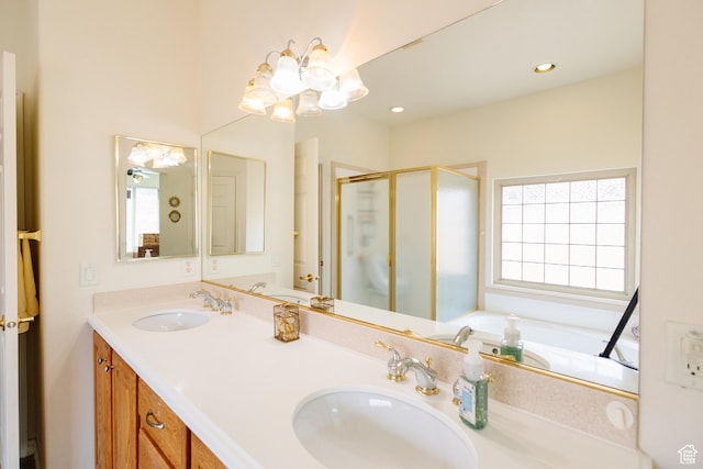 full bathroom with a wealth of natural light, a notable chandelier, and a sink