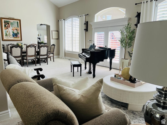 sitting room with arched walkways, light carpet, and baseboards
