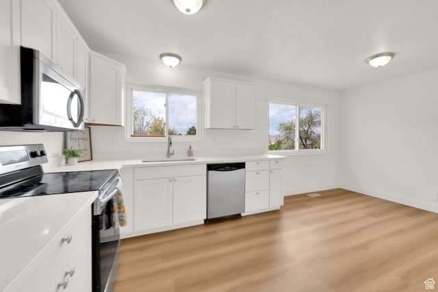 5148 W Redflower Cir, West Valley City, UT 84120 - kitchen with white cabinets, stainless steel appliances, a sink, light wood-style floors, and light countertops
