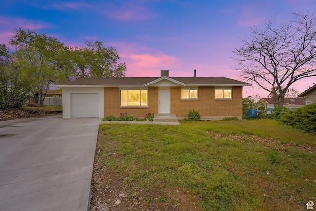 5148 W Redflower Cir, West Valley City, UT 84120 - view of front facade featuring a front lawn, driveway, fence, a garage, and brick siding