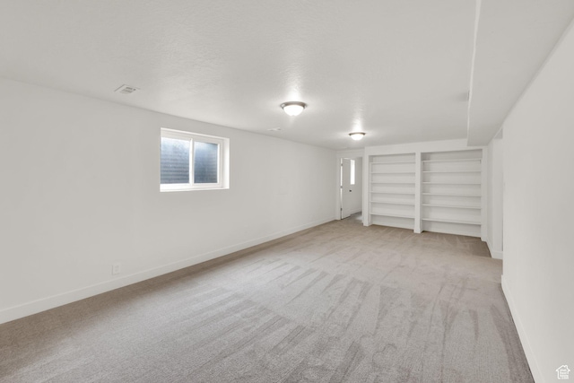 5148 W Redflower Cir, West Valley City, UT 84120 - basement with light carpet, built in features, a textured ceiling, and baseboards