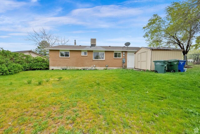 5148 W Redflower Cir, West Valley City, UT 84120 - back of property featuring brick siding, an outbuilding, a yard, and a storage unit