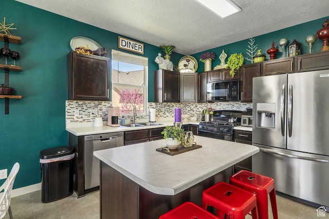 6961 W Goblin Valley Cv S, West Jordan, UT 84081 - kitchen with dark brown cabinets, a textured ceiling, a sink, and black appliances