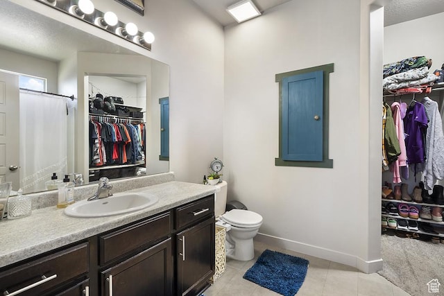6961 W Goblin Valley Cv S, West Jordan, UT 84081 - full bath with tile patterned flooring, toilet, vanity, a walk in closet, and baseboards