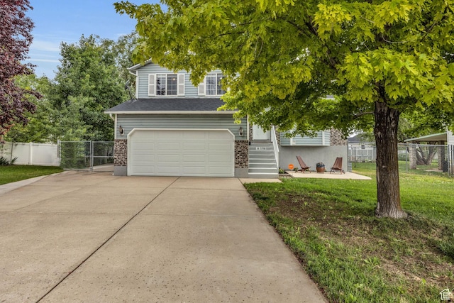 view of front of house with an attached garage, a front lawn, concrete driveway, and fence