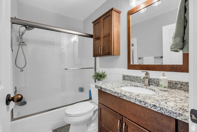 bathroom with vanity, enclosed tub / shower combo, and toilet