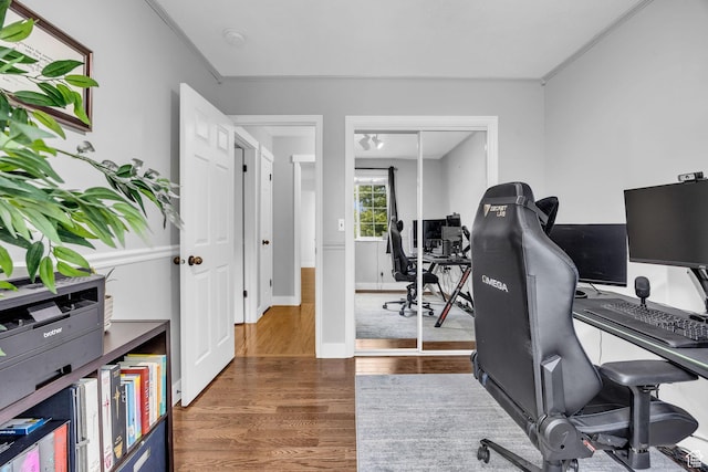 office area featuring baseboards, wood finished floors, and ornamental molding
