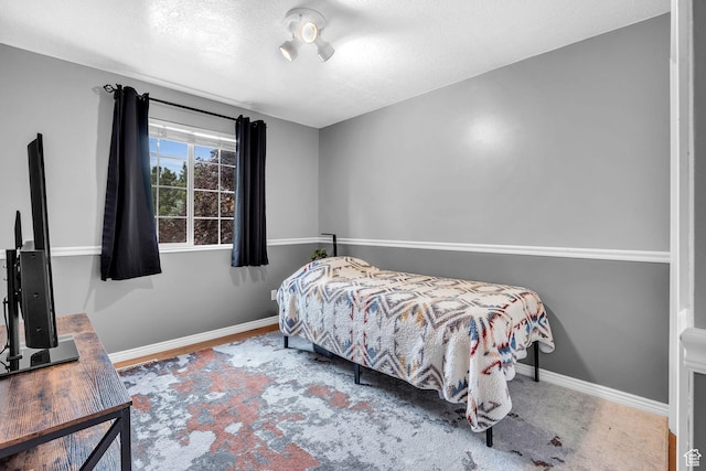 bedroom featuring a textured ceiling and baseboards