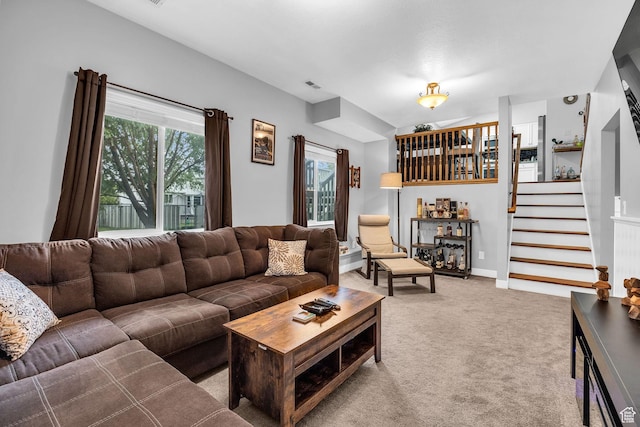 carpeted living area with baseboards, stairway, visible vents, and a dry bar