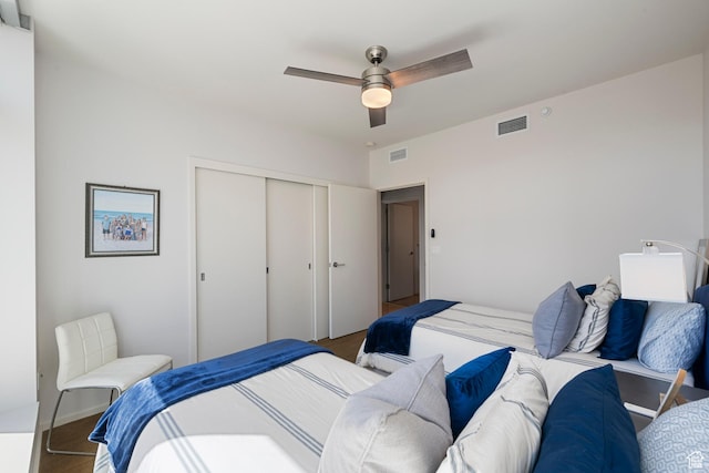 bedroom featuring wood finished floors, visible vents, and a closet