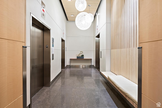 hall with elevator and a towering ceiling