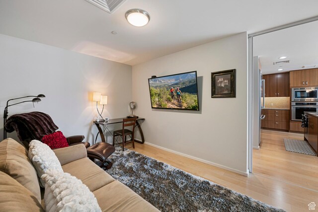 living room with recessed lighting, light wood-type flooring, visible vents, and baseboards
