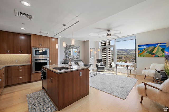 kitchen featuring light wood finished floors, visible vents, appliances with stainless steel finishes, and open floor plan