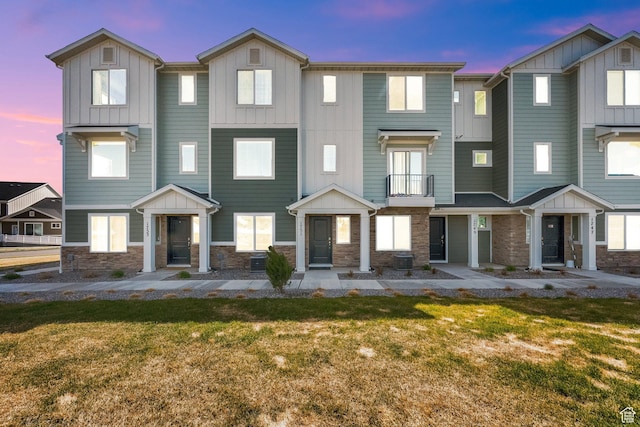 1751 E Wolverine Way, Eagle Mountain, UT 84005 - multi unit property featuring board and batten siding, stone siding, a front lawn, and a balcony