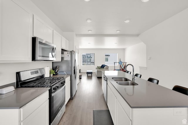 1751 E Wolverine Way, Eagle Mountain, UT 84005 - kitchen with dark countertops, appliances with stainless steel finishes, a center island with sink, and a sink