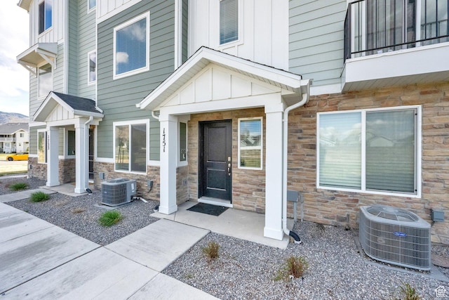 1751 E Wolverine Way, Eagle Mountain, UT 84005 - entrance to property featuring board and batten siding, stone siding, and central AC unit