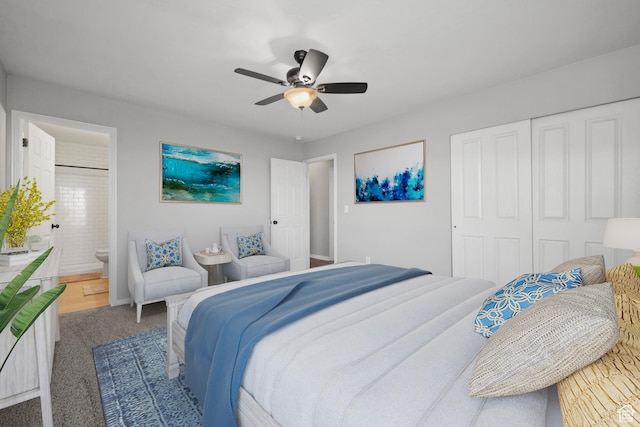 carpeted bedroom with a closet, a ceiling fan, and ensuite bath