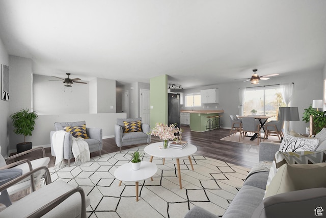 living room with a ceiling fan, wood finished floors, and baseboards
