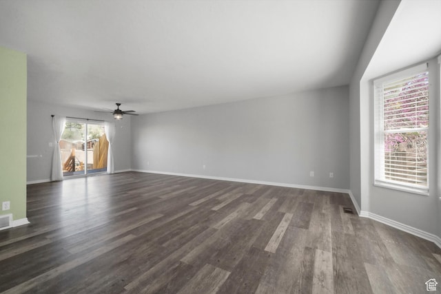 unfurnished living room with ceiling fan, visible vents, dark wood finished floors, and baseboards