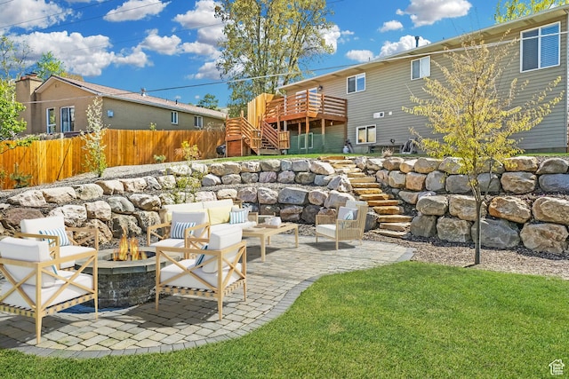 exterior space featuring a wooden deck, a patio area, an outdoor fire pit, stairs, and fence