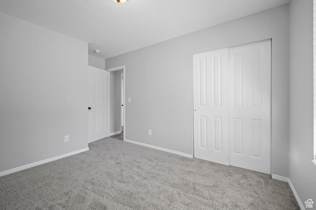 unfurnished bedroom with a closet, baseboards, and carpet floors