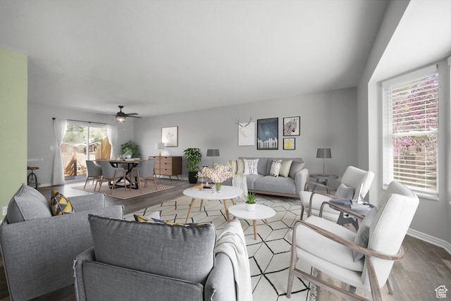 living area with wood finished floors, ceiling fan, and baseboards