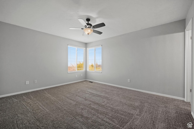 carpeted spare room with a ceiling fan and baseboards