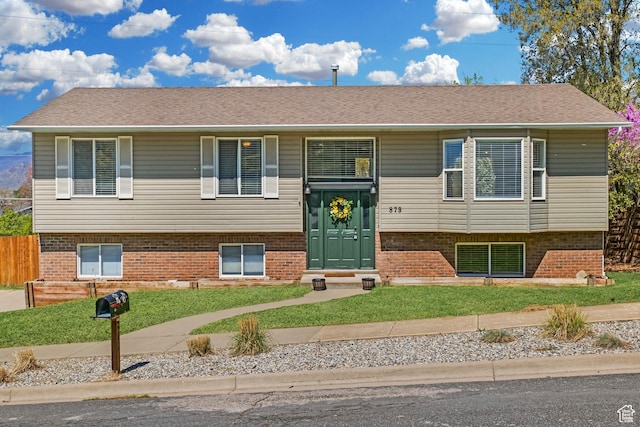 bi-level home featuring brick siding and a front lawn