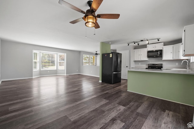 unfurnished living room featuring track lighting, ceiling fan, a sink, baseboards, and dark wood-type flooring