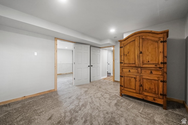 finished below grade area featuring baseboards, recessed lighting, and light carpet