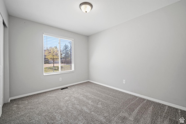 unfurnished room with visible vents, carpet flooring, and baseboards