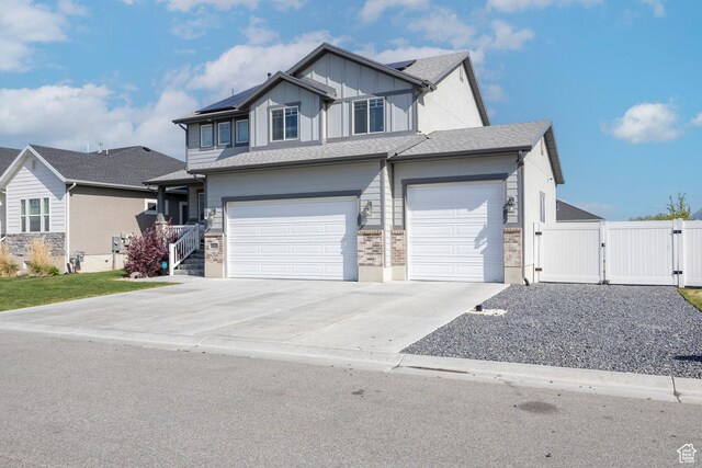 2448 W Anne Ave S, West Haven, UT 84401 - view of front facade with a gate, driveway, fence, a garage, and roof mounted solar panels
