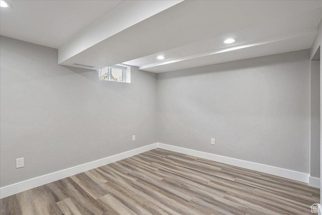 basement featuring baseboards, wood finished floors, and recessed lighting