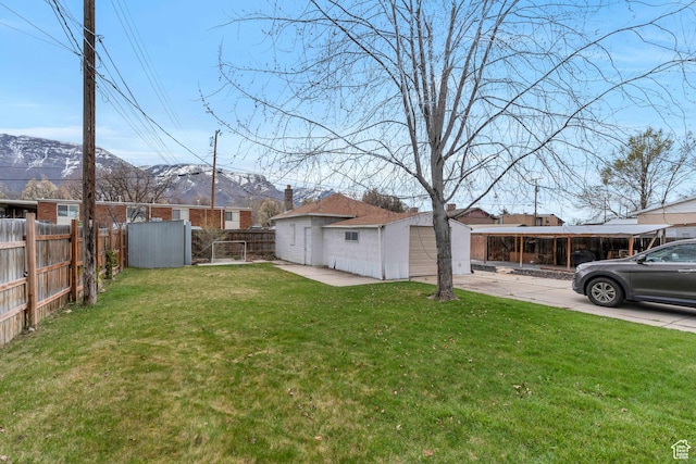 682 N 700 W, Provo, UT 84601 - view of yard featuring an outdoor structure, concrete driveway, fence, and a mountain view