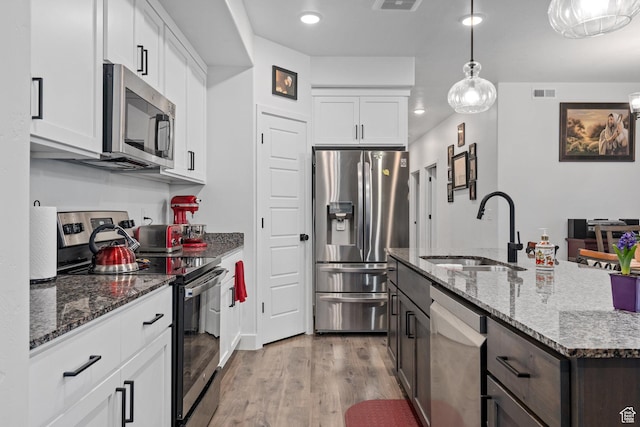 551 S 1020 W Unit 102, American Fork, UT 84003 - kitchen featuring light wood finished floors, a sink, visible vents, white cabinetry, and appliances with stainless steel finishes
