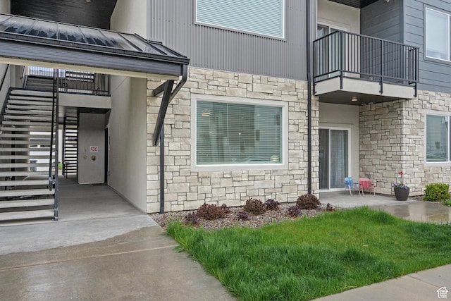 551 S 1020 W Unit 102, American Fork, UT 84003 - entrance to property featuring stone siding, a standing seam roof, a balcony, and metal roof