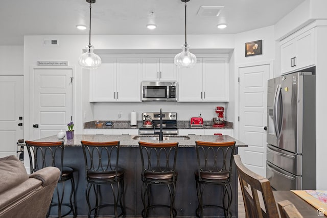 551 S 1020 W Unit 102, American Fork, UT 84003 - kitchen with white cabinets, a kitchen bar, visible vents, and stainless steel appliances