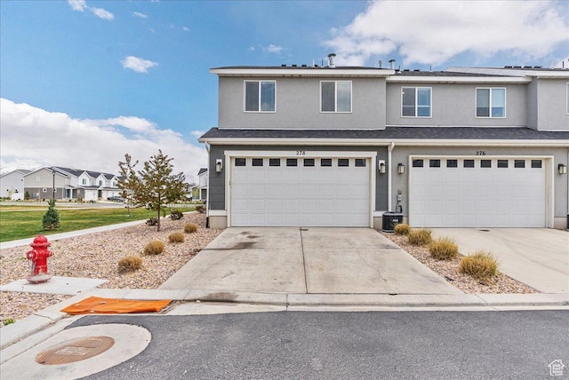 278 N Portside Ln, Saratoga Springs, UT 84045 - view of front facade with a garage, driveway, and stucco siding
