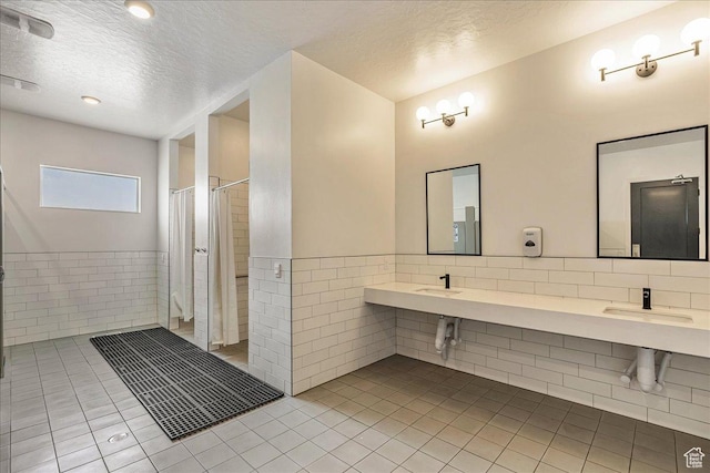 278 N Portside Ln, Saratoga Springs, UT 84045 - bathroom with a shower with curtain, tile patterned floors, a textured ceiling, and tile walls