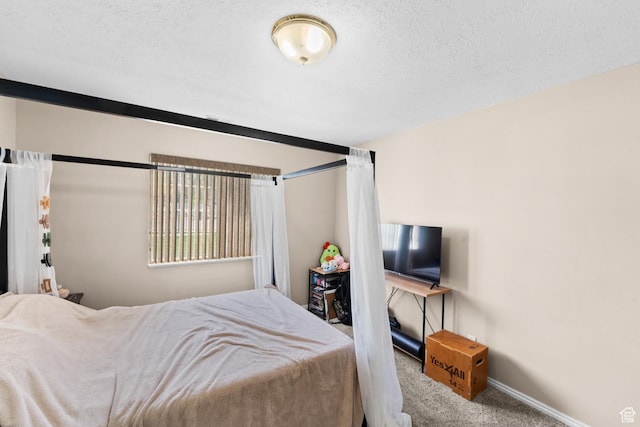 carpeted bedroom with baseboards and a textured ceiling