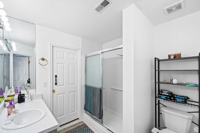 full bathroom with visible vents, toilet, a shower stall, and vanity