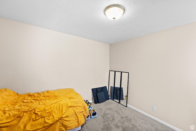 unfurnished bedroom featuring carpet floors, a textured ceiling, and baseboards