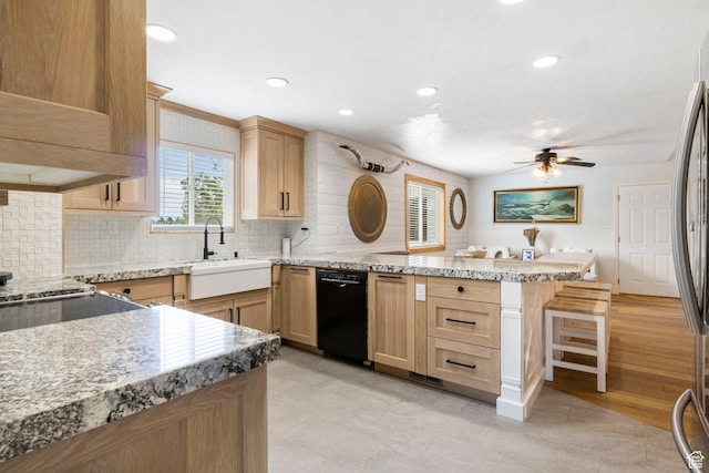 kitchen with a sink, a peninsula, black dishwasher, tasteful backsplash, and a ceiling fan