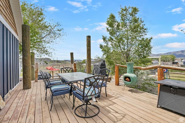 wooden terrace featuring outdoor dining area and a mountain view
