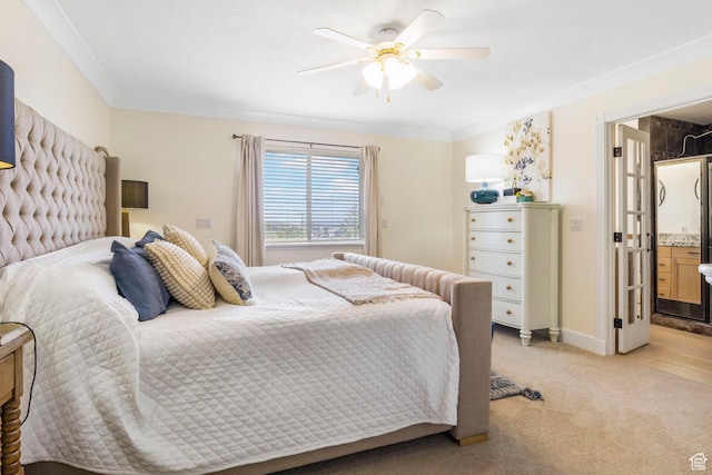 bedroom featuring ceiling fan, light colored carpet, crown molding, baseboards, and ensuite bath